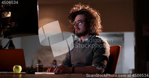 Image of man working on computer in dark office