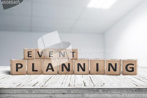 Image of Event planning sign on a wooden desk in an office