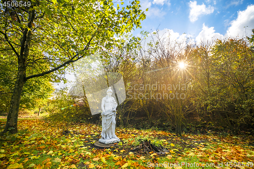 Image of Sculpture in a park with colorful autumn leaves