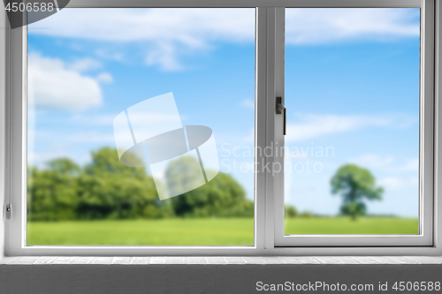 Image of View from a closed window to a green meadow