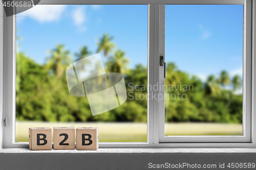 Image of B2B sign in a window on a tropcal island with palm trees