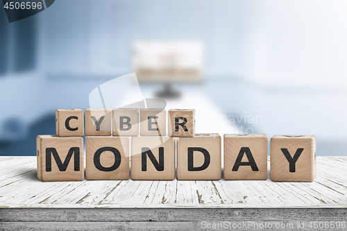 Image of Cyber monday sign on a wooden desk with a monitor
