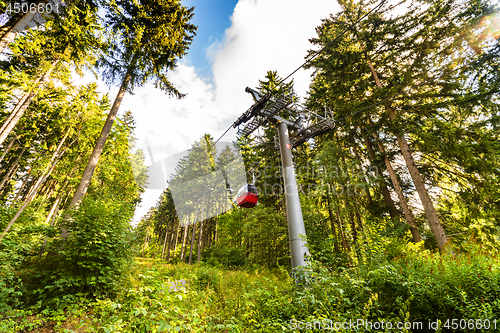 Image of Mountain lift going up in a green forest