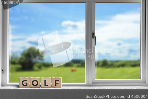 Image of Golf sign in a window with a view to a golf course