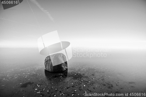 Image of Single rock in the water by the sea