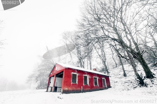 Image of Red barn in a misty winter landscape 