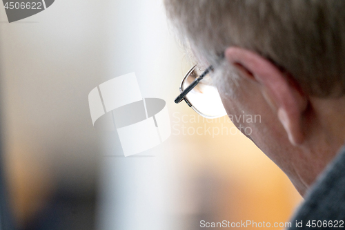 Image of Senior male looking through a pair of glasses