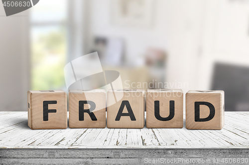 Image of Fraud sign made of wooden blocks on a white desk
