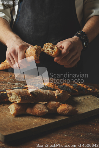 Image of Male hands break the baguette