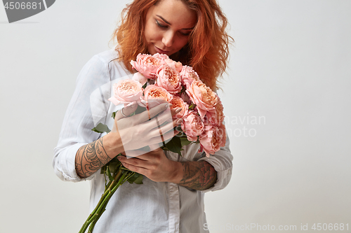 Image of the girl is holding a bouquet of pink roses