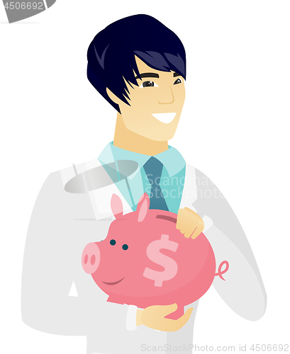 Image of Young asian doctor holding a piggy bank.