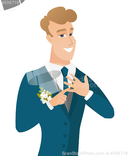 Image of Cheerful groom showing golden ring on his finger.