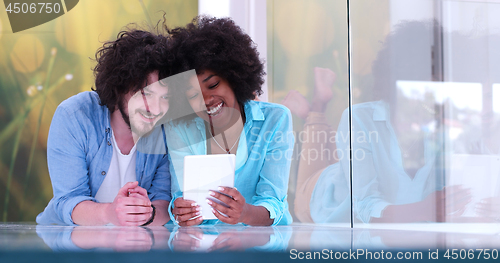 Image of Couple relaxing together at home with tablet computer