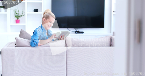 Image of woman on sofa using tablet computer