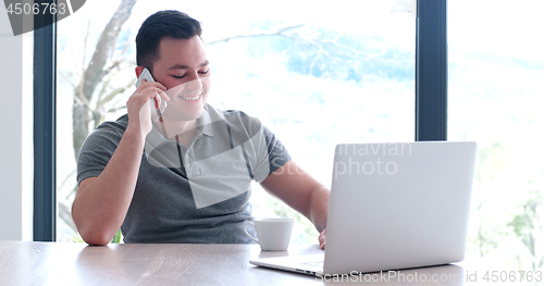 Image of businessman working using a laptop in startup office