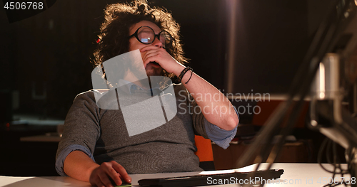 Image of man working on computer in dark office