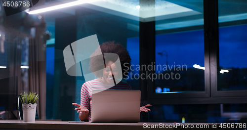 Image of black businesswoman using a laptop in night startup office