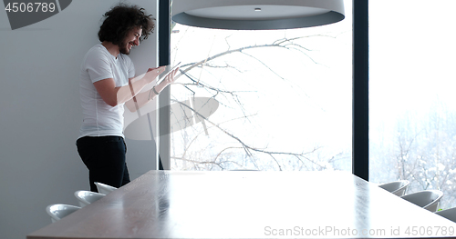 Image of young man using a tablet at home