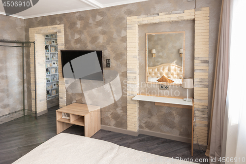 Image of Fragment of the interior of a one-room apartment with a TV and dressing table