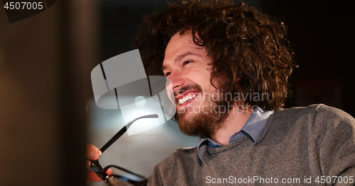 Image of man working on computer in dark office