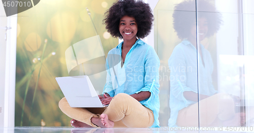 Image of black women using laptop computer on the floor