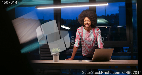 Image of black businesswoman using a laptop in night startup office