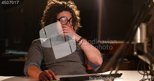 Image of man working on computer in dark office