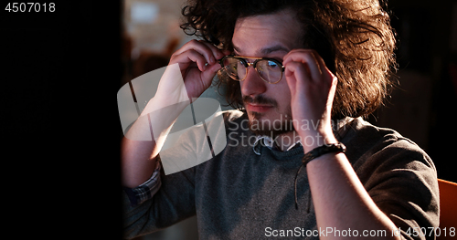 Image of man working on computer in dark office