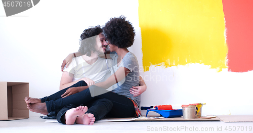 Image of young multiethnic couple relaxing after painting