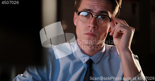 Image of man working on computer in dark office