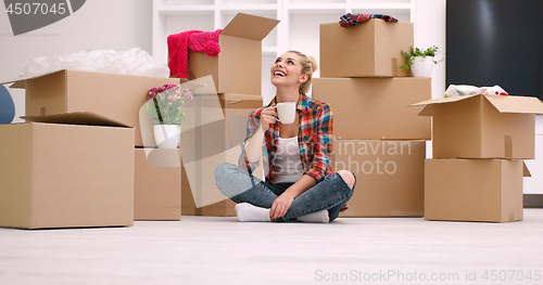 Image of woman with many cardboard boxes sitting on floor