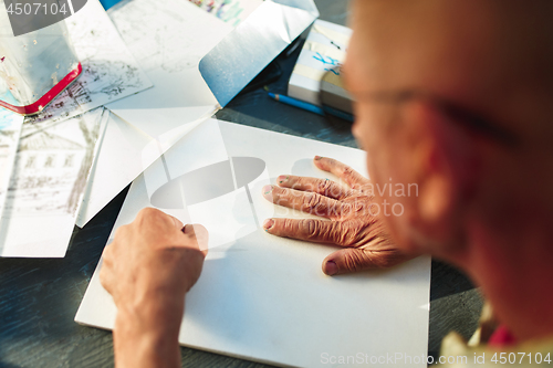 Image of Close up man working of Architect sketching a construction project on his plane project at site construction work