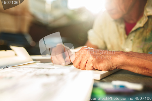 Image of Close up man working of Architect sketching a construction project on his plane project at site construction work