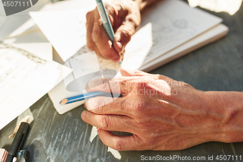 Image of Close up man working of Architect sketching a construction project on his plane project at site construction work