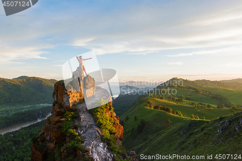 Image of Man standing on top of cliff