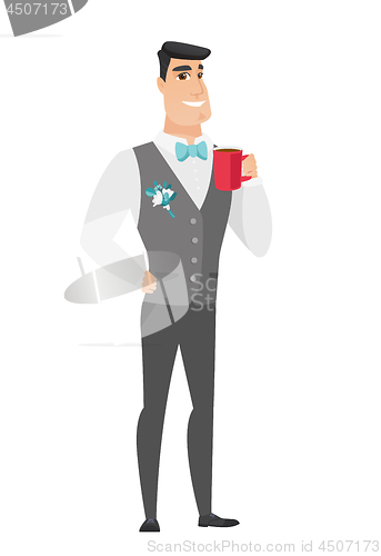 Image of Young caucasian groom holding cup of coffee.