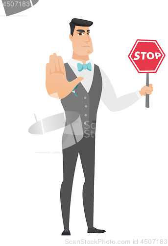 Image of Caucasian groom holding stop road sign.