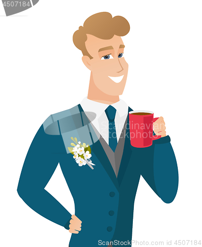 Image of Young caucasian groom holding cup of coffee.