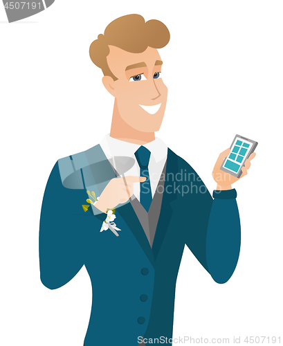 Image of Young caucasian groom holding a mobile phone.