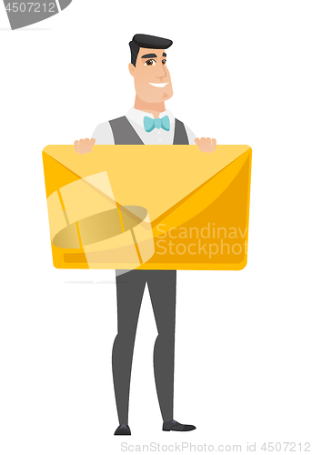 Image of Smiling groom holding a big envelope.