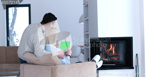 Image of couple relaxing at  home with tablet computers