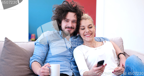 Image of Young couple on the sofa watching television