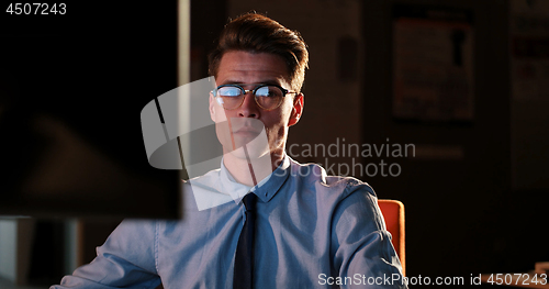 Image of man working on computer in dark office