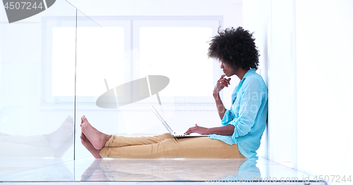 Image of black women using laptop computer on the floor