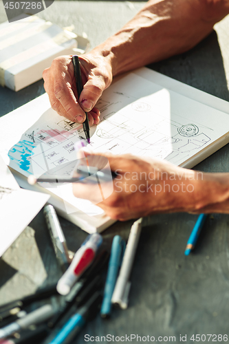 Image of Close up man working of Architect sketching a construction project on his plane project at site construction work
