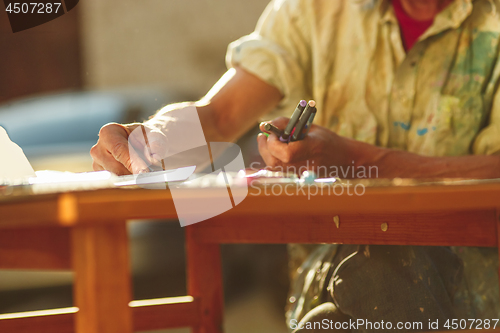 Image of Close up man working of Architect sketching a construction project on his plane project at site construction work