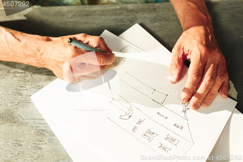 Image of Close up man working of Architect sketching a construction project on his plane project at site construction work