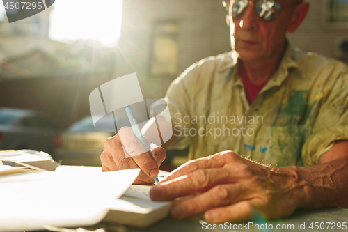 Image of Close up man working of Architect sketching a construction project on his plane project at site construction work