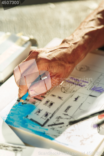 Image of Close up man working of Architect sketching a construction project on his plane project at site construction work