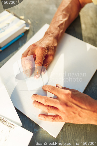 Image of Close up man working of Architect sketching a construction project on his plane project at site construction work